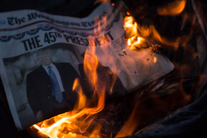 A few violent members of the anti-Trump protest at Franklin Square light trashcan fires in the middle of the street using Trump paraphernalia and todays Inaugural newspaper edition for fuel.